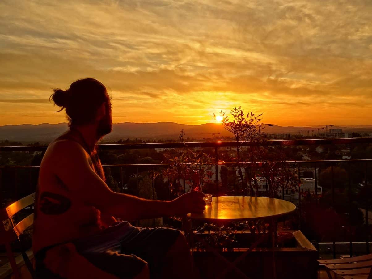 Man overlooking sunset balcony