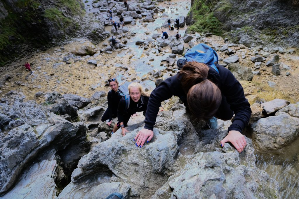 Hikers climbing up a rockface