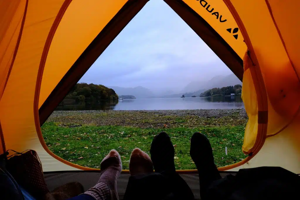 Couple camping in a tent with lake view