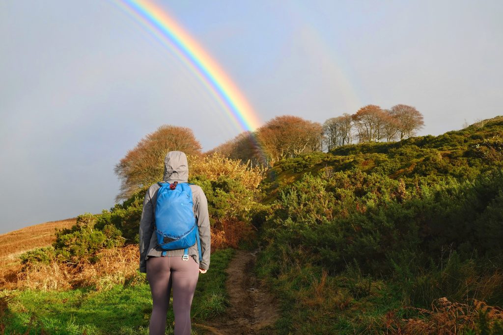 Girl hiking under rainbow