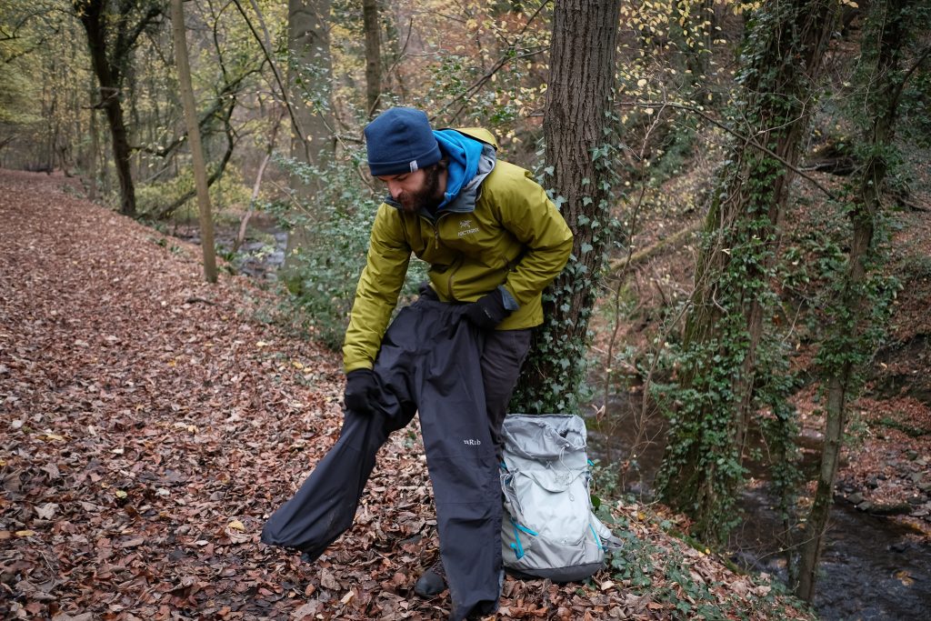 Man putting on hiking rain pants