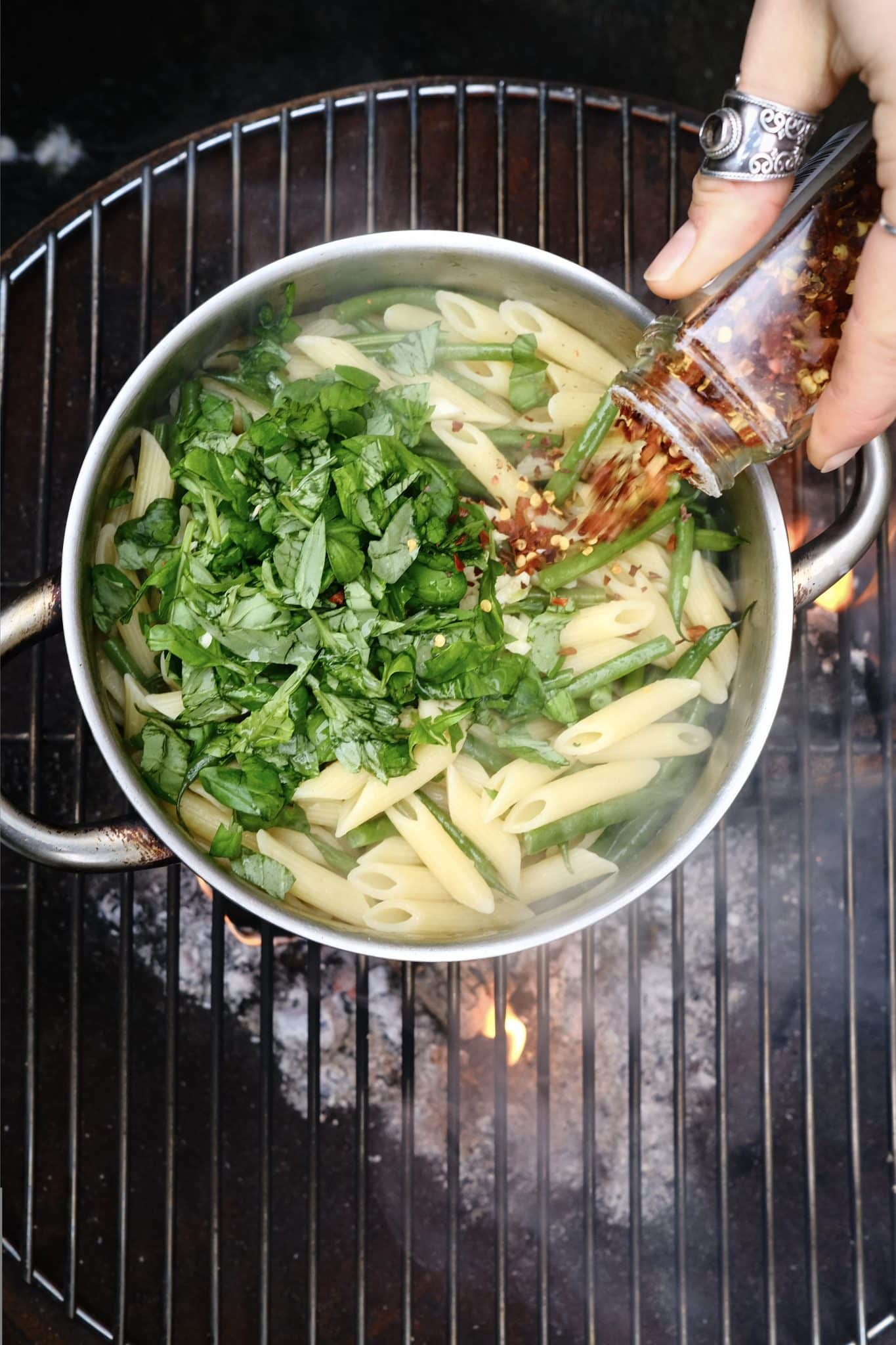 Red pepper flakes being poured onto lemon pasta