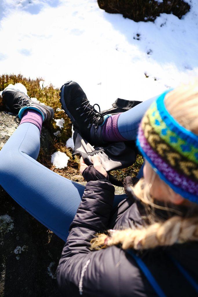 Girl putting on winter hiking gaiters