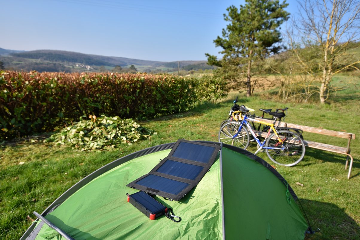 Charging battery pack from solar charger on top of tent in field