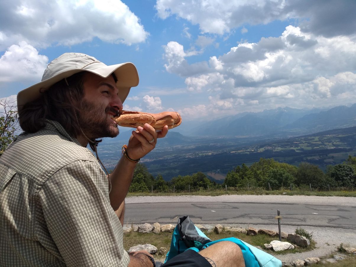 Hiking man having lunch in the sun