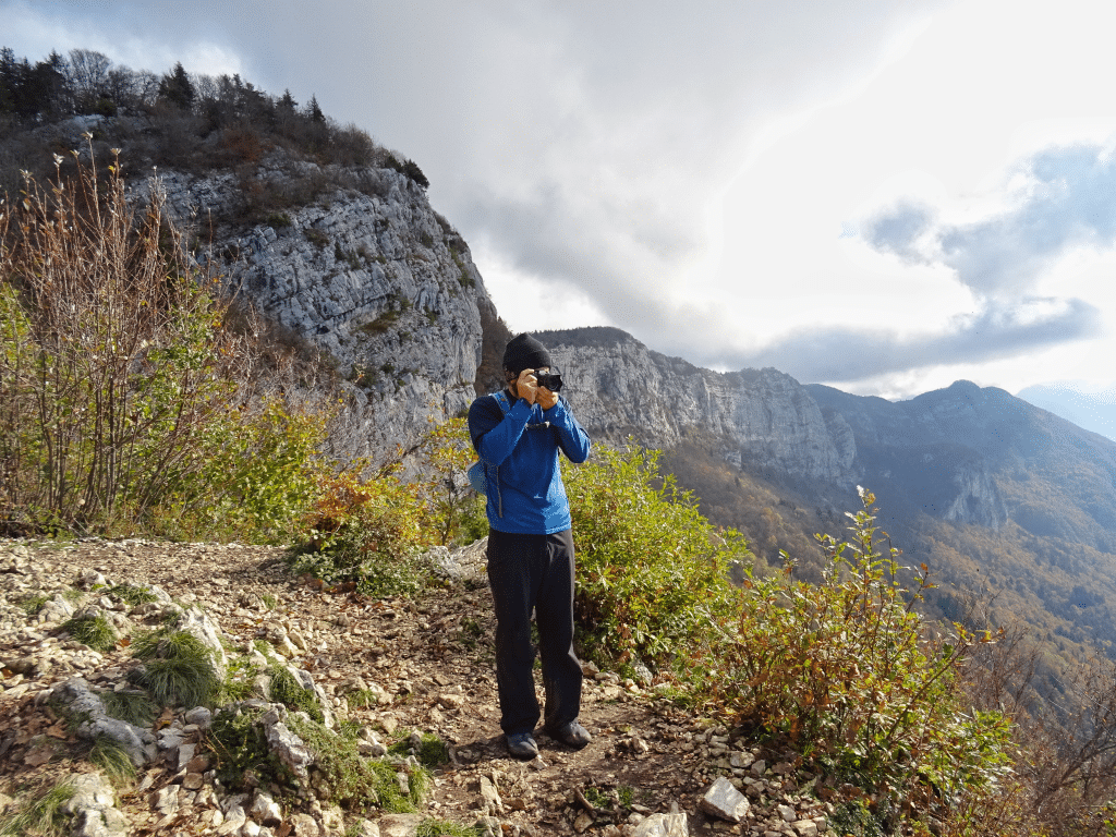 Man taking mountain photography whilst hiking