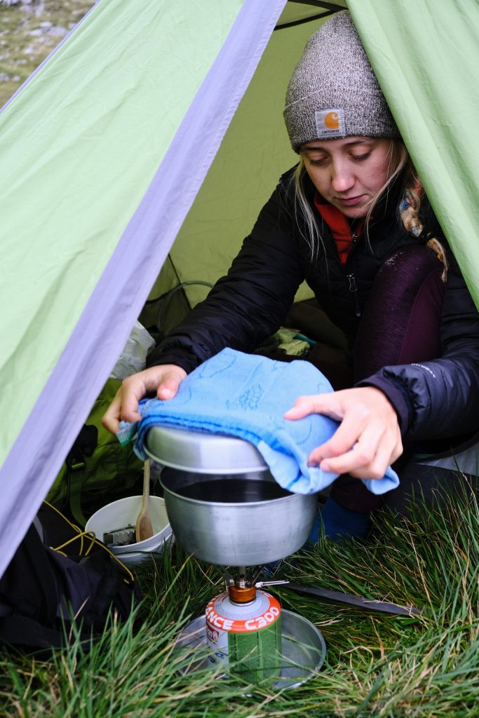 Girl cooking whilst wild camping 