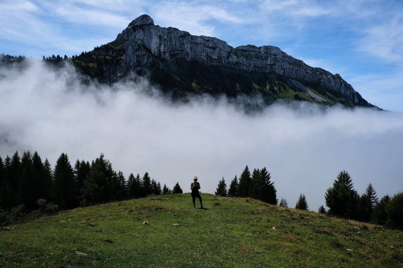 Girl hiking above clouds 