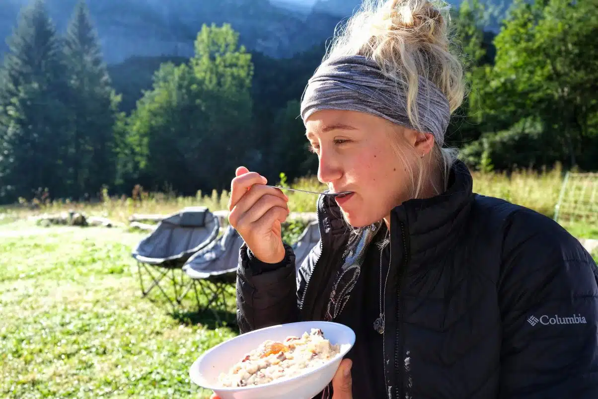 Sustainable female camper eating porridge 