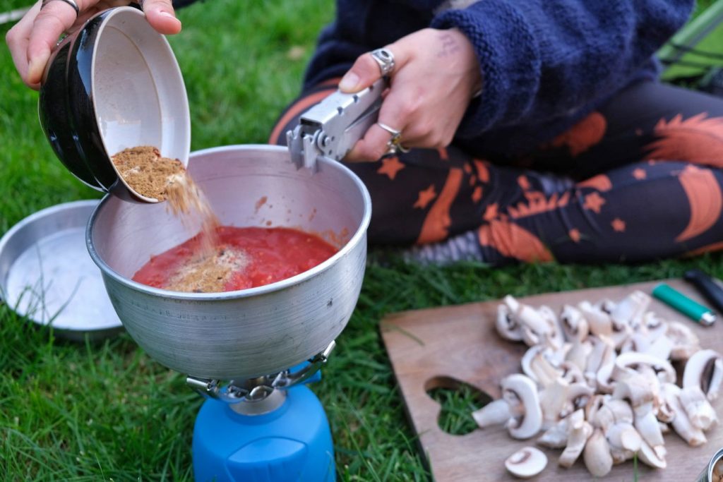 Pouring spice mix into peanut butter curry 