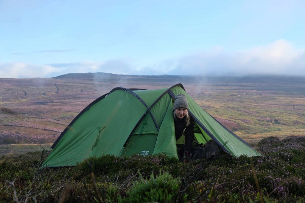 Girl wild camping watching sunrise