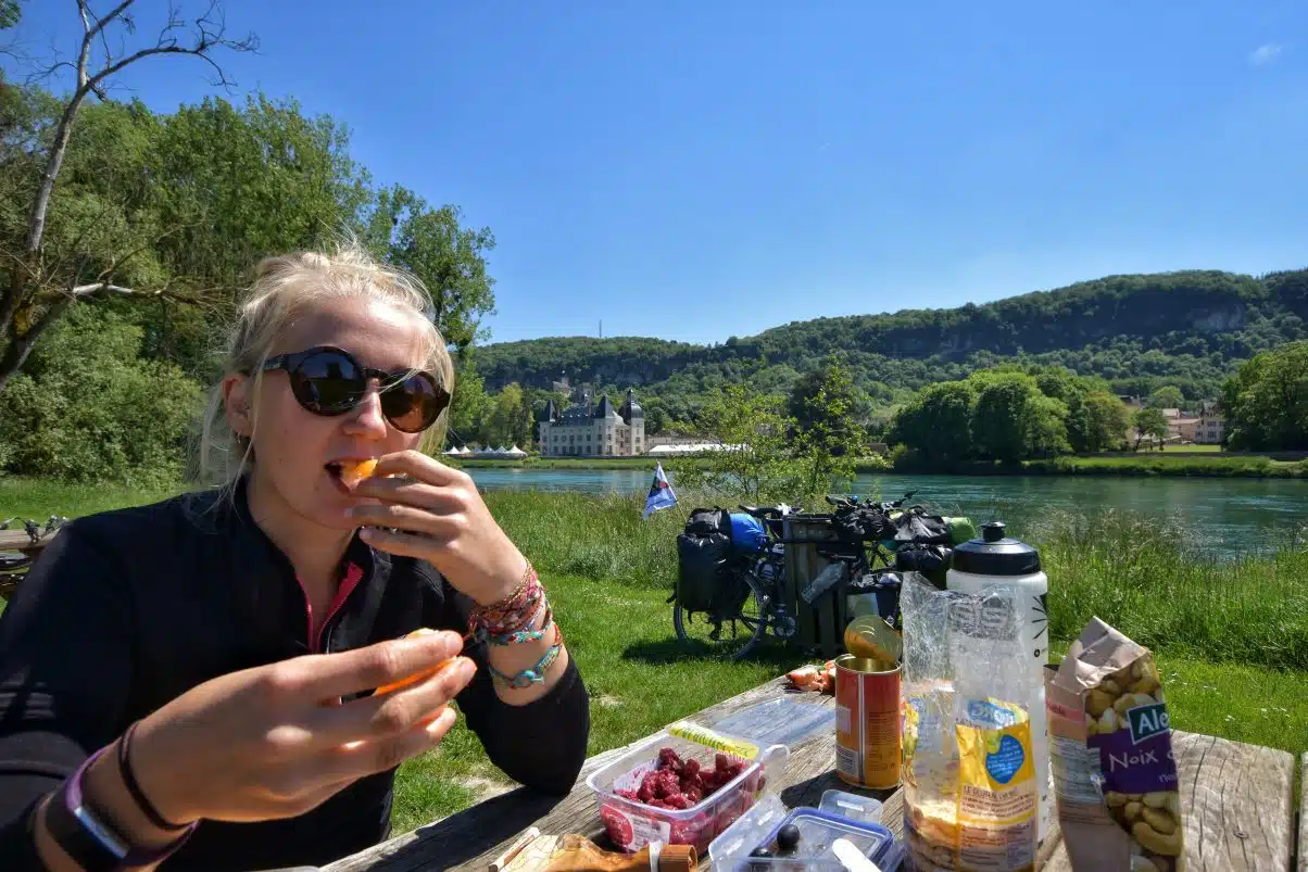 Cyclist eating lunch by Lake 