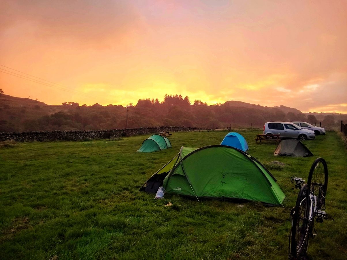 Sunrise over a tent in mountains 