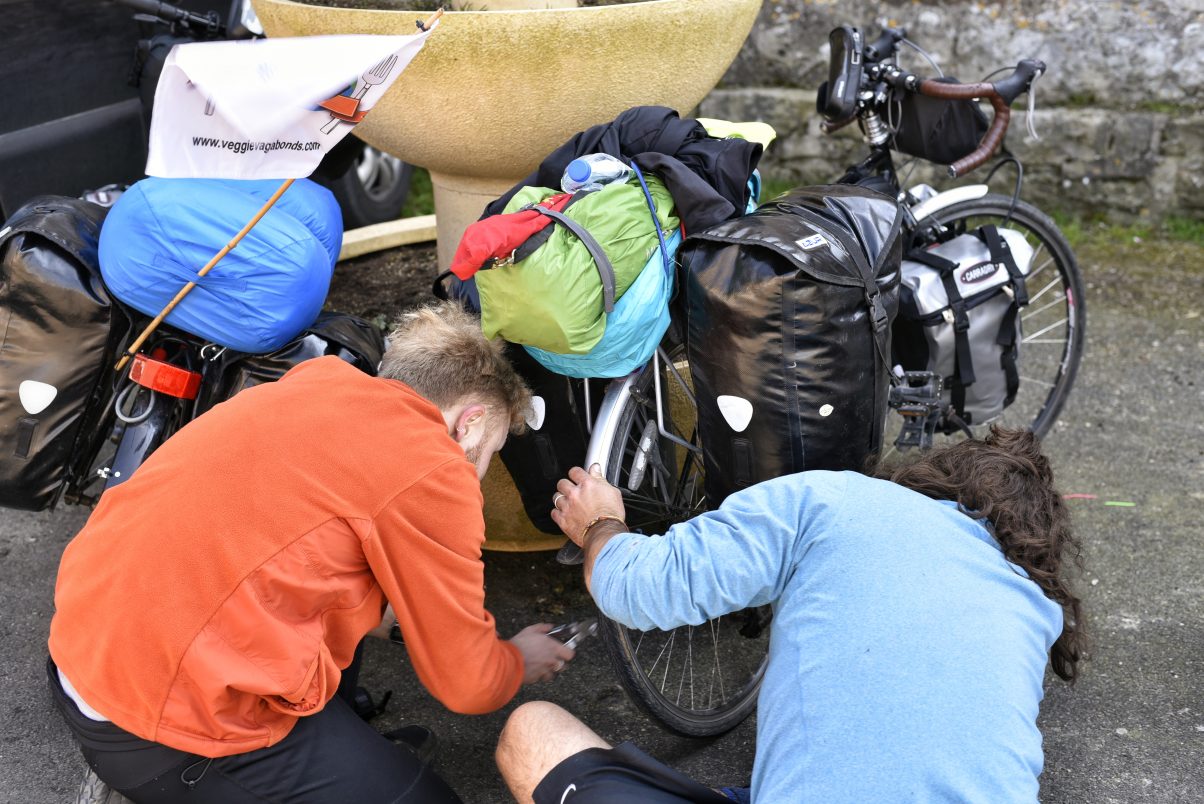 Two men fixing touring bikes