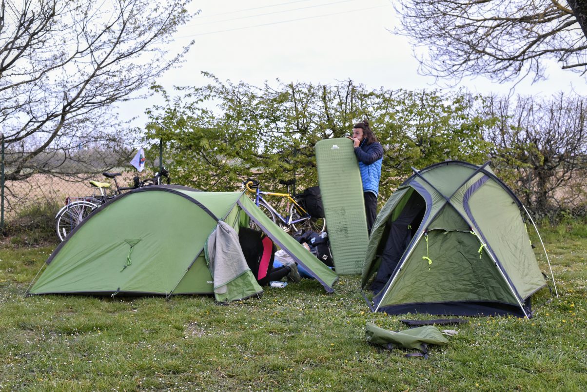 Sustainable camping gear and man pitching tent 